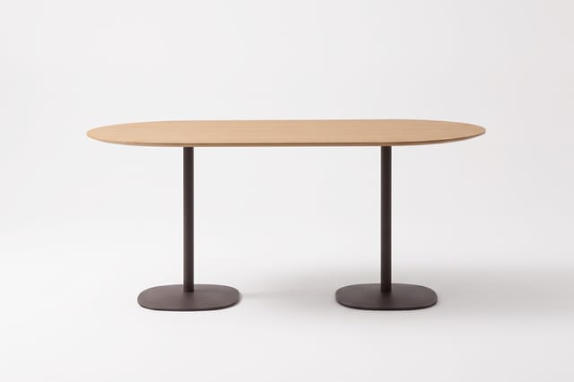Inclass Floe ovale tafel met een licht houtkleurig blad en twee donkere kolompoten op afgeronde voetplaten.