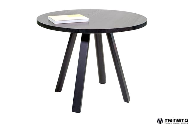 Ronde zwarte houten tafel met vier zwarte poten, notitieboeken op het blad, vrijstaand tegen witte achtergrond.