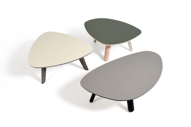 Drie organisch gevormde lage tafels in beige, groen en grijs met houten of zwarte poten, weergegeven in 3D-rendering.