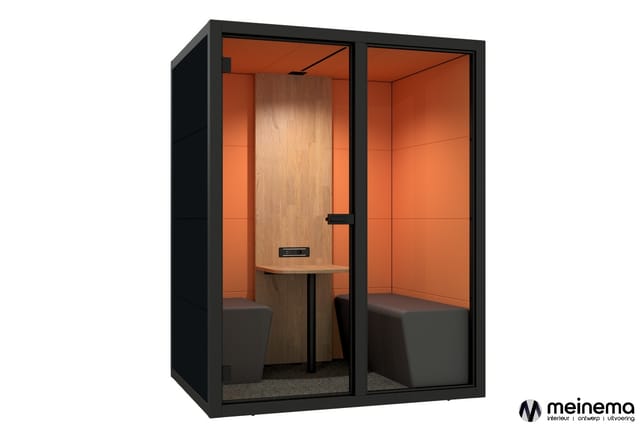 Zwarte belcel met oranje binnenwanden, houten achterwand, ingebouwde tafel en grijze zitplaatsen voor twee personen.