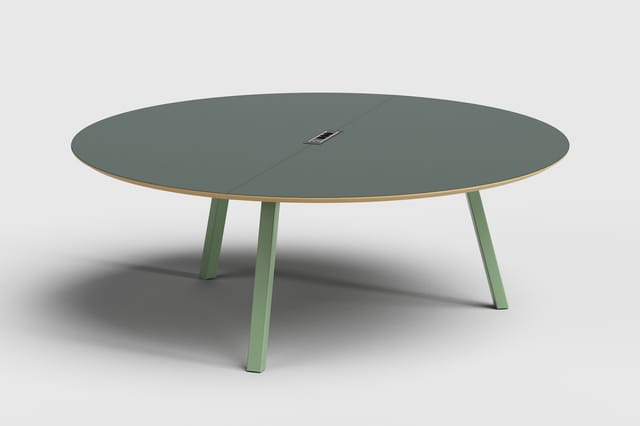 Ronde vergadertafel met grijsgroene tafelblad, houten rand en groene poten. Centraal stroomvoorziening ingebouwd.