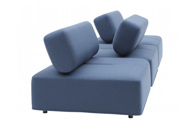 Blauwe moderne fauteuil met ronde kussens, geometrische vormen en zwarte poten op witte achtergrond.