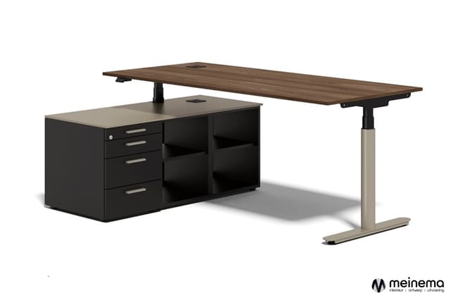 Elektrisch instelbaar bureau met donkergrijs blad, beige onderstel en zwarte kastunit met laden en open vakken.