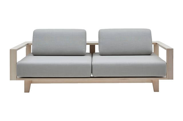Houten 2-zits bank met grijze gestoffeerde zitting en rugkussens, rechte armsteun en minimalistisch design.