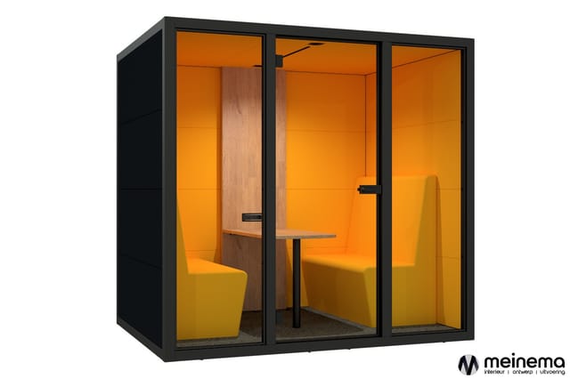 Moderne belcel met zwart frame, oranje wanden, houten scheidingswand, gele stoelen en kleine tafel. Gesloten werkplek voor co