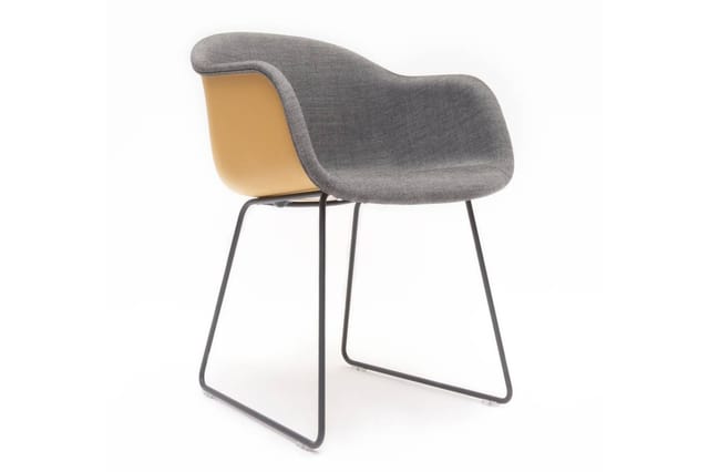 Grijze stoel met armleuningen, geel/beige kunststof rug en zwart metalen sleden onderstel.