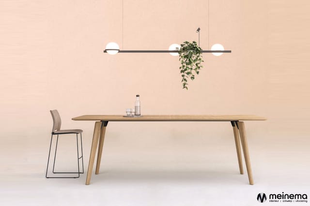 Houten vergadertafel met natuurlijke afwerking, grijze barstoel, hangende lineaire lamp met drie witte bollen en hangende pla