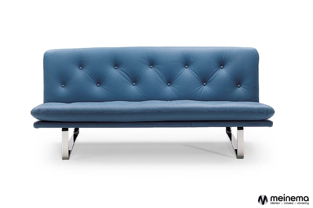 Blauwe futon bank met gestikt rugkussen, zilveren metalen poten, minimalistische vorm, vrijstaand tegen witte achtergrond.