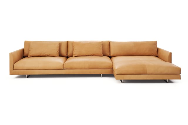Caramelkleurige leren hoekbank met drie zitplaatsen en chaise longue, moderne vormgeving met metalen poten.