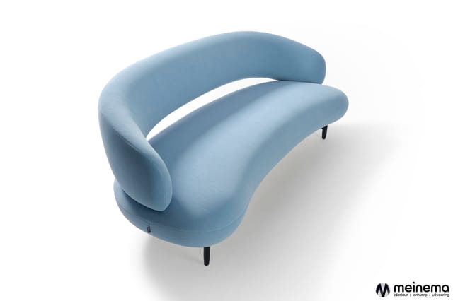 Blauwe fauteuil met organische, afgeronde vormen en zwarte poten tegen witte achtergrond.