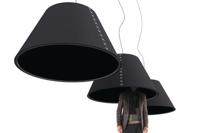 Drie zwarte kegelvormige hanglampen met stitching detail, één met persoon eronder, tegen witte achtergrond.
