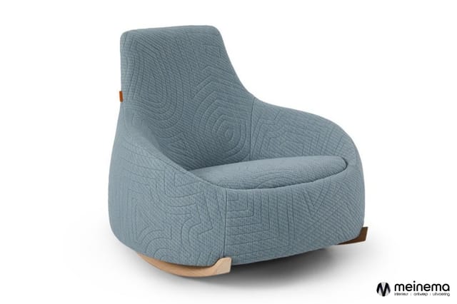 Grijsblauwe schommelfauteuil met gestoffeerde zitting, houten rockers en bruin lederen armsteun.