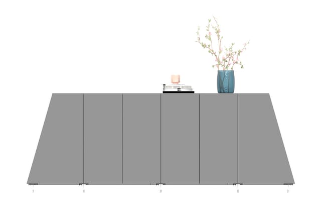 Grijze vergadertafel met getextureerde oppervlakte, voorzien van een blauwe vaas met bloemen, boeken en decoratieve objecten.