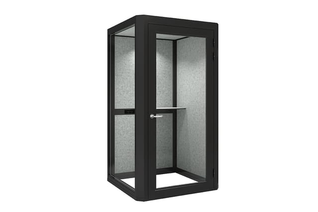 Zwarte akoestische telefooncel met grijze geluidsdempende wanden, glazen deur en metalen handgreep.