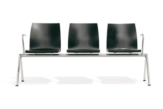 Wachtbankje met drie zwarte kunststof zitschalen op metalen frame met armleuningen.