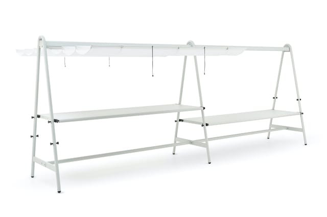 Wit metalen hangrek met twee trapeziumvormige frames, twee horizontale legplanken, ophangstang bovenaan en draadverbindingen.