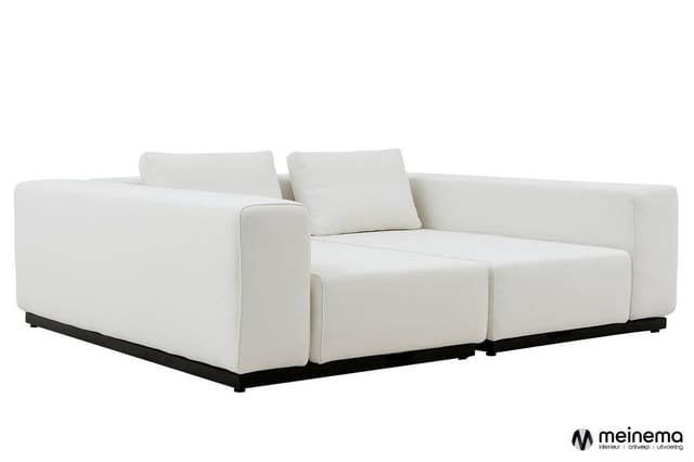 Witte modulaire bank met gewatteerde zitting, twee rugkussens, zwart metalen onderstel, twee zitplaatsen.