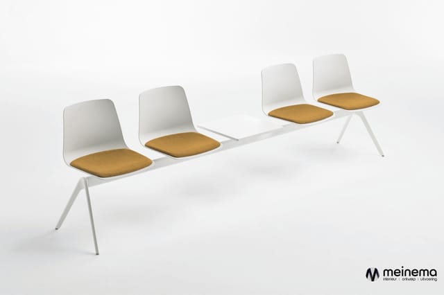 Wachtruimte-zitbank met vier witte kunststof stoelen met gele/okergekleurde zitkussens en wit metalen frame.