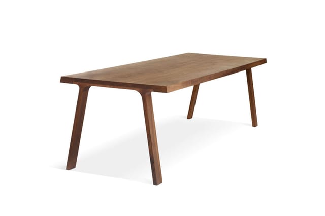 Houten vergadertafel met donkerbruine afwerking en schuine poten, rechthoekig blad, vrijstaand tegen witte achtergrond.