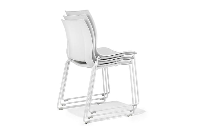 Drie gestapelde witte kantoor(bezoekers)stoelen met aluminium frame en voetsteunen, op wit oppervlak.