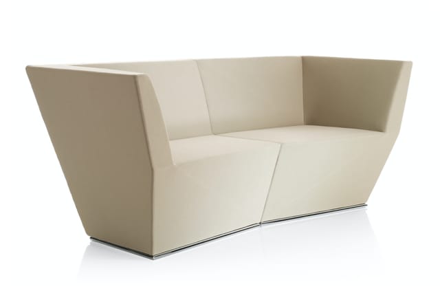 Crèmekleurige loungzetel met hoge zijwanden, brede zitting en metallic onderstel tegen witte achtergrond.