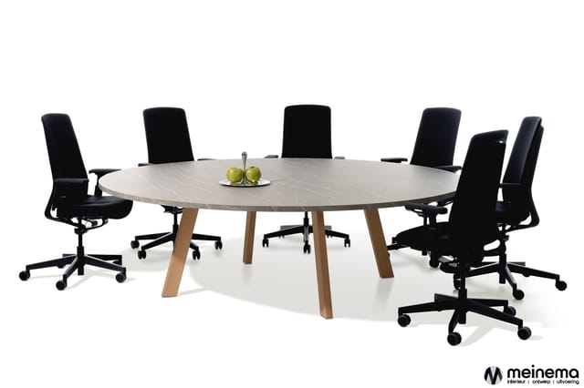 Ronde vergadertafel met licht marmerblad en houten poten, omringd door zes zwarte ergonomische bureaustolen met wieltjes.