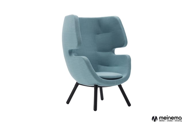 Blauwe fauteuil met hoge, gesloten rugleuning en zijpanelen, zwarte poten, zitplaats met donker kussen tegen witte achtergron