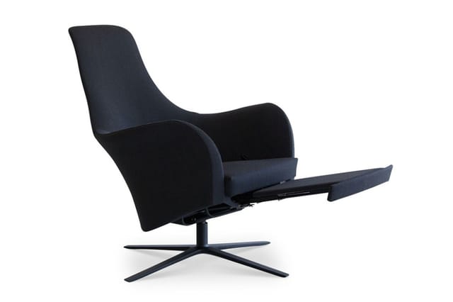Zwarte relaxstoel met voetsteun, gebogen rugleuning en zwart kruisvoetgestell, op witte achtergrond.