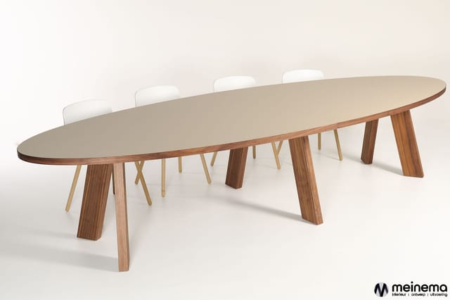 Lange ovale vergadertafel met beige blad, houten onderstel in walnoot- en natuurtinten, met witte ergonomische stoelen.