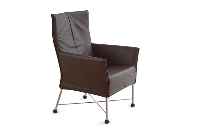 Bruine leren fauteuil met hoge rugleuning, metalen frame met wieltjes en kruis-onderstel, tegen witte achtergrond.