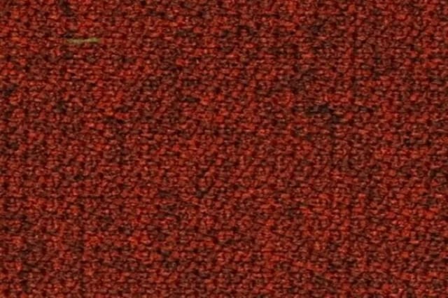 Textielmonster in rood-bruine melange kleur met gestructureerde weefseltextuur.