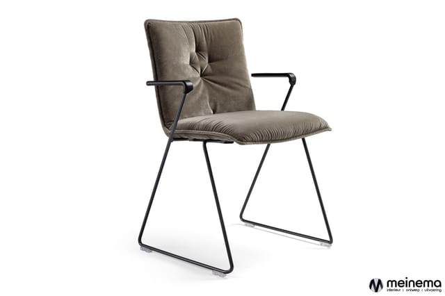 Grijsbeige stoel met gestoffeerde zitting en rugleuning, zwart metalen frame met lage slaapkuip, armsteunen, op witte achterg