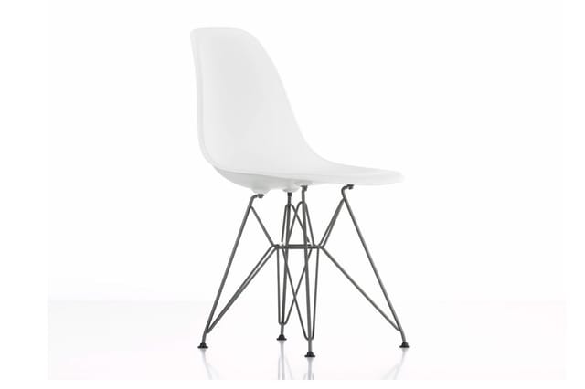 Witte kunststof stoel met zwart metalen spinnenpootframe, zijprofiel tegen witte achtergrond.