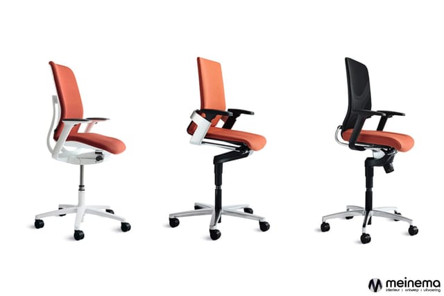 Drie kantoorstoelenmodellen met oranje/rood zitting, zwenkvoet en wielen: witte frame links, zwart-witte frame midden, zwart