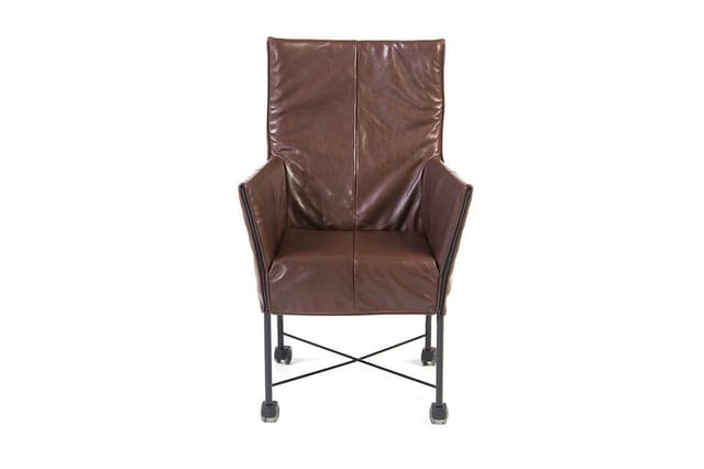 Bruine leren fauteuil met hoge rugleuning op zwart metalen onderstel met wielen en kruisverbinding.