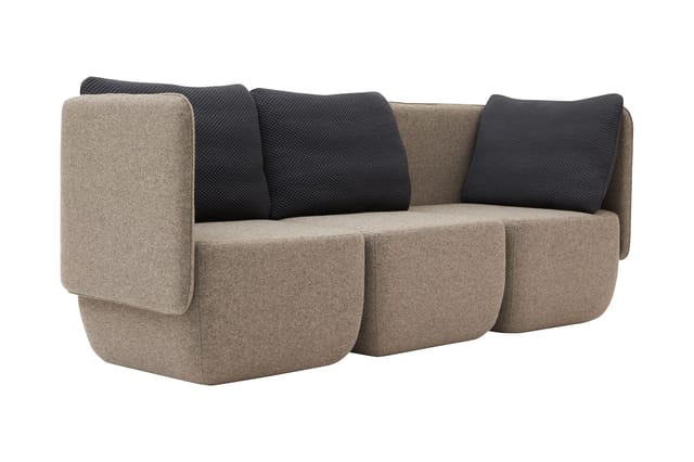 Modulaire bank met afgeronde vormen in beige wol en zwarte textiel kussens, drie zitplaatsen met gebogen armleuningen.