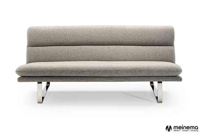 Grijze stofbeklede loungebank met horizontale stiksels, zitgedeelte en metalen frames, tegen witte achtergrond.