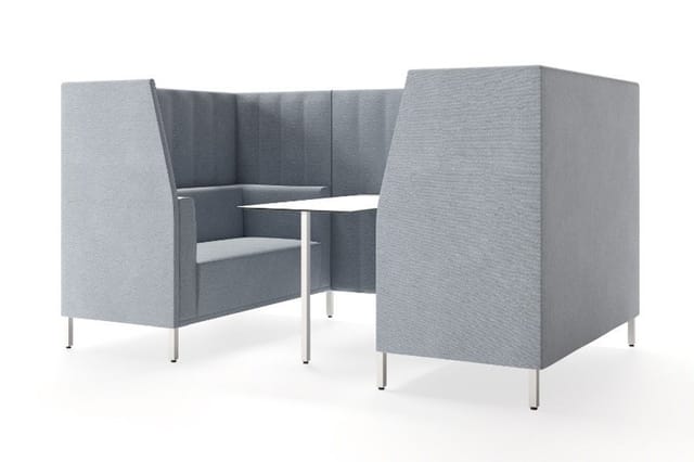 Grijze akoestische vergaderbox met twee hoekige zitgedeelten, wit tafeltje en metalen poten.