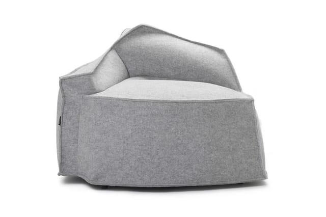 Grijze fauteuil met afgeronde vormen, gestoffeerd in melange stof, met lichte zitting en donkerder rug- en armleuningen.