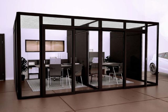 Zwarte glazen belcel met werkplekken, stoelen en kasten in showroomomgeving met witte wanden.