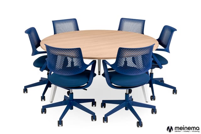 Ronde vergadertafel met licht houtfineer, omringd door zes blauwe bureaustoelen met meshrug en wieltjes.