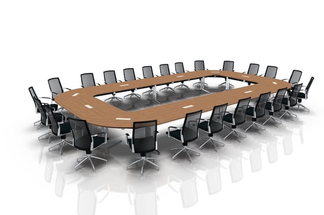 Grote vergadertafel met houten blad en zilveren onderstel, omringd door zwarte bureaukstoelen met grijze rugleuning.