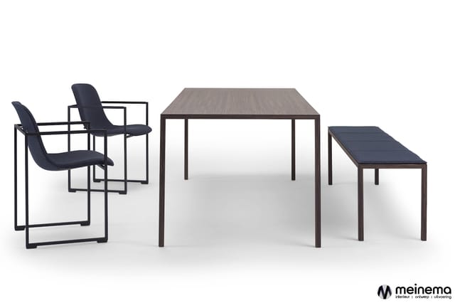 Minimalistisch kantoorinterieur met twee zwarte stoelen met armleuningen, grijze houten tafel en donker houten bankje tegen w