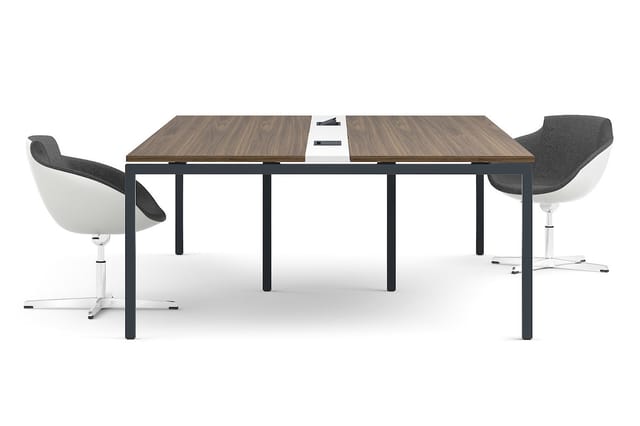 Vergadertafel met walnootkleurig blad en zwart metalen onderstel, twee grijze draaistoelen met wit onderstel, wit centerpiece