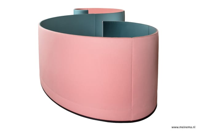 Roze gefabriceerde zitbank met teal-blauwe binnenzijde, curved vorm, zwart onderstel, compartimentering zichtbaar.