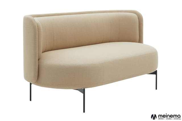 Beige/zandkleurige sofa met afgeronde vormen, hoge gebogen rugleuning en zwarte metalen poten, vrijstaande opstelling.