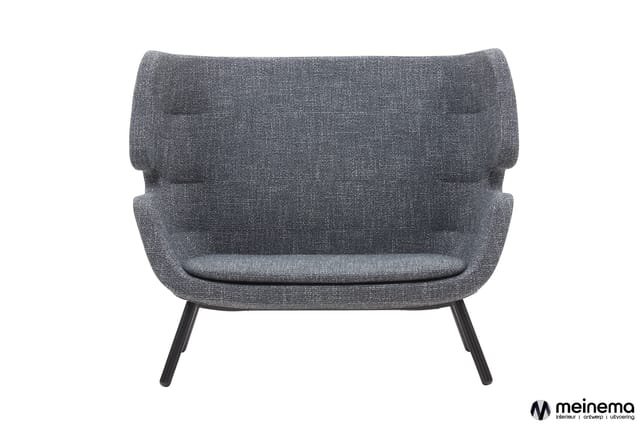 Grijze fauteuil met gewatteerde armleuningen en rugleuning, zwarte poten, frontaanzicht tegen witte achtergrond.