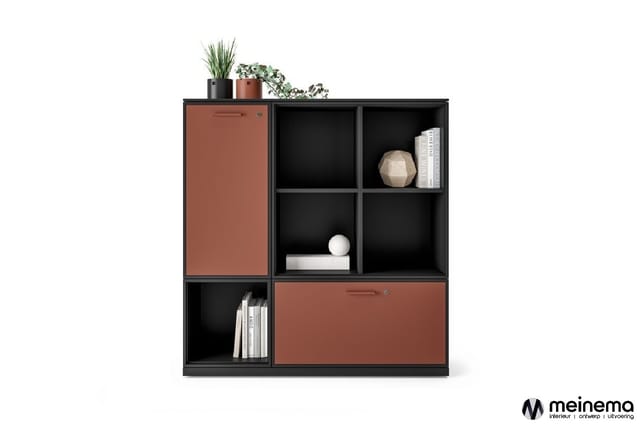 Zwart-bruine modulaire boekenkast met open vakken, gesloten deuren en decoratieve items zoals planten, boeken en accessoires.