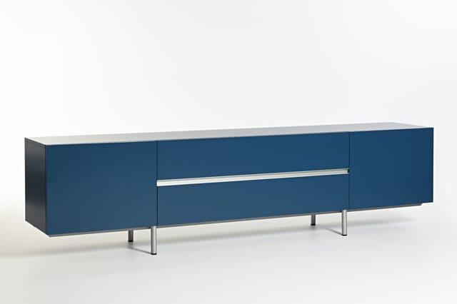 Blauwe sideboard met wit blad, drie deuren en één lade met metalen handgreep, op metalen poten.